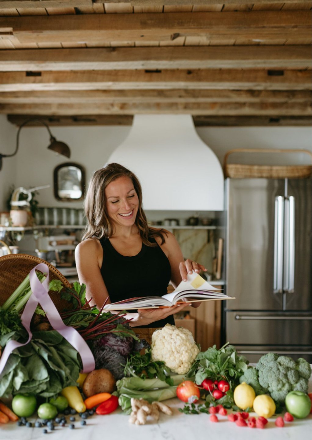 Aubrey with cookbook in rustic kitchen